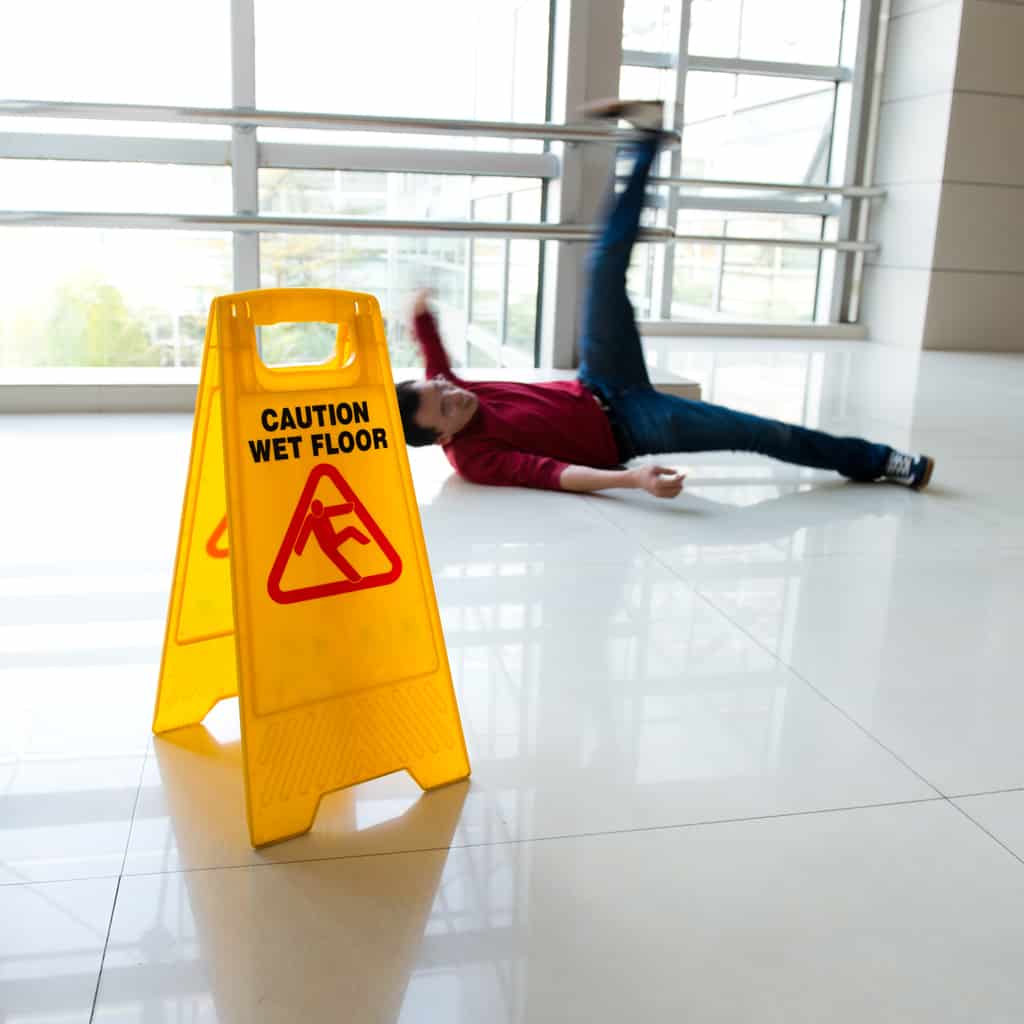 Man slipped on wet floor with wet floor sign nearby