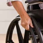 person in wheelchair close up on hand on wheel