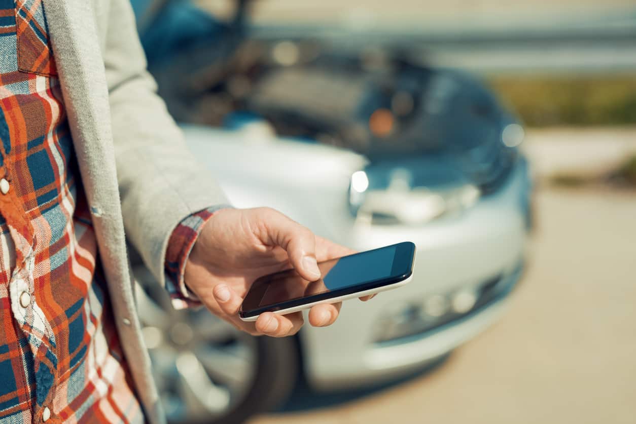 Man using smartphone after traffic accident