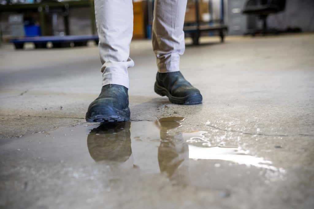 worker-in-a-warehouse-walking-in-spilled-liquid